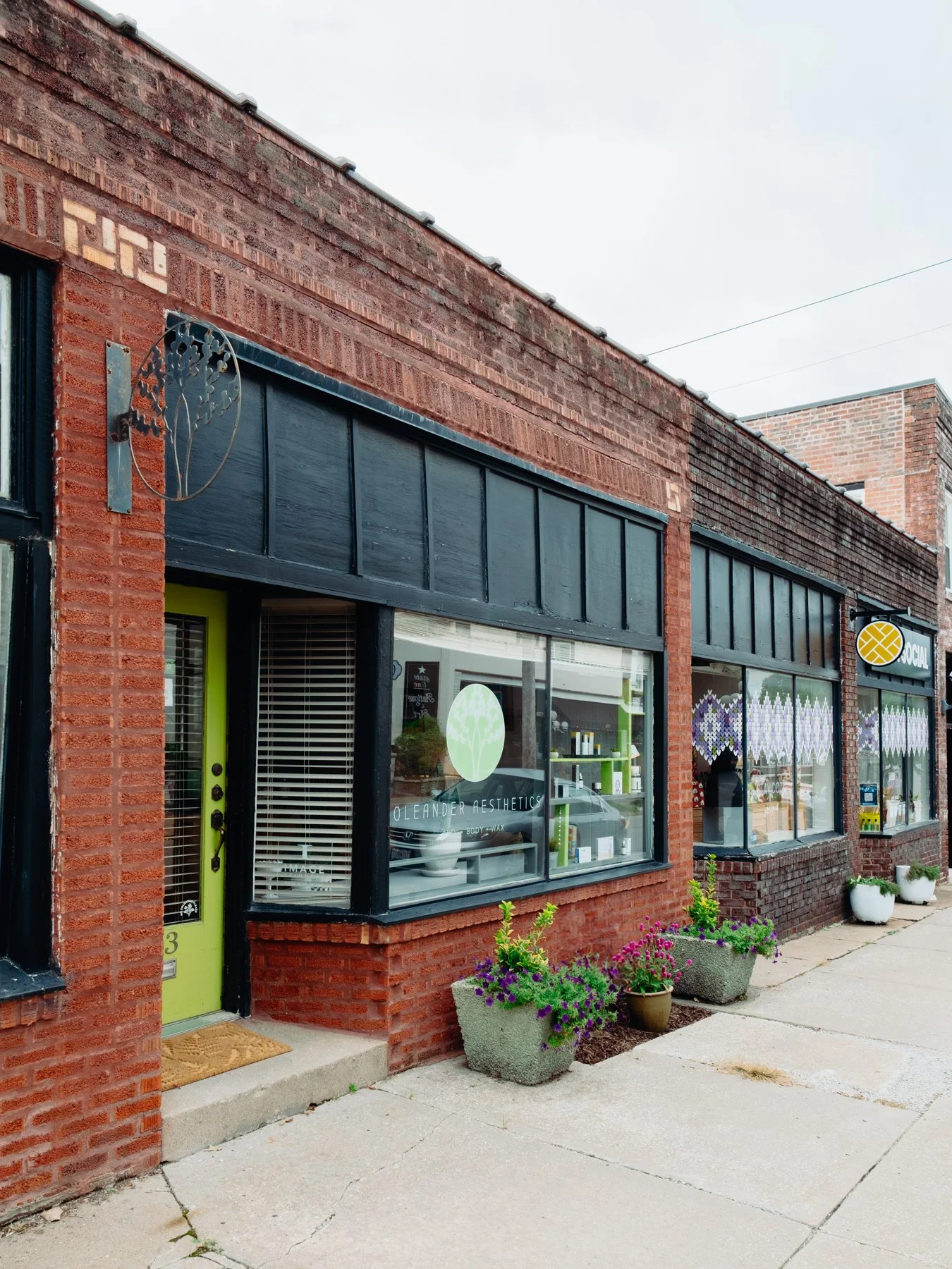 A brick storefront with green window frames