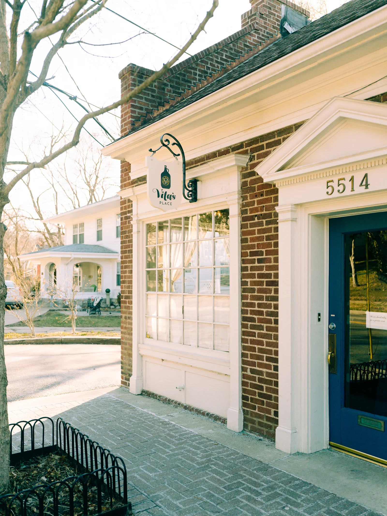 Vita’s Place storefront with a blue door in afternoon light